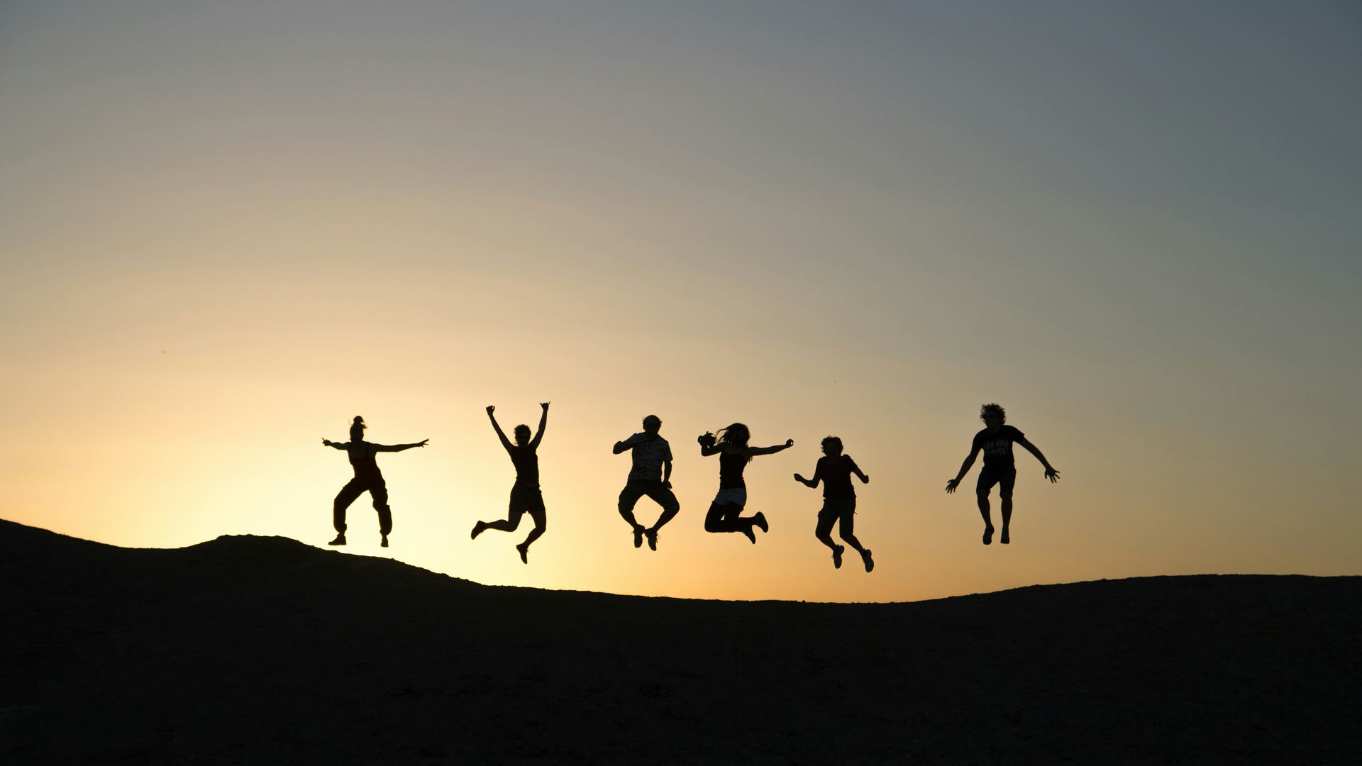 Group of people in front of a sunset